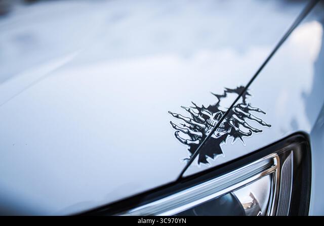 spooky sticker with skeleton hands gripping a skull on a car hood Die Cut Vinyl Decal