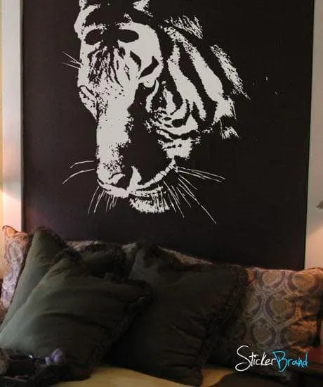 A white decal of a tiger's face on a black wall near a couch. Die Cut Vinyl Decal